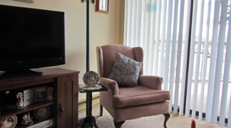 View of two bedroom living room with cozy chair